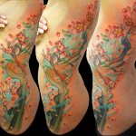 Татуировка с цветузим деревом на боку